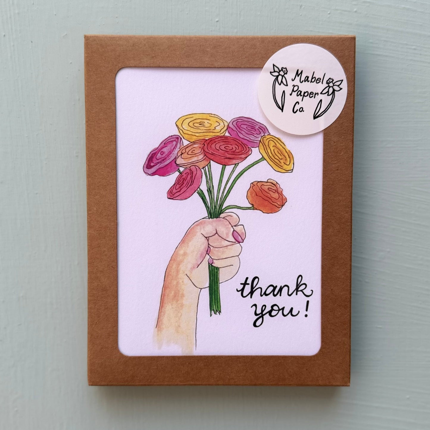 Card with a hand holding flowers and 'thank you!' text
