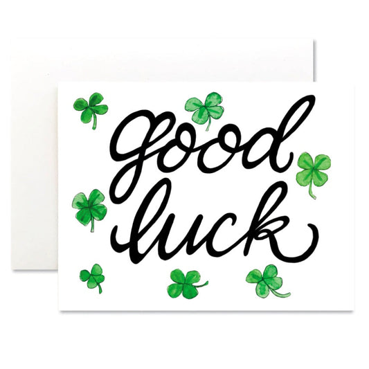 Card with 'Good luck' text and green shamrocks on a white background